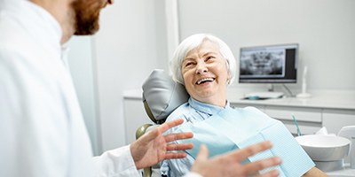 Dentist and older female patient discussing All-on-4