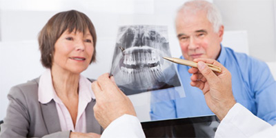 An older couple examining an X-ray.