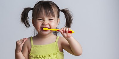 Happy little girl brushes her teeth after visiting children’s dentist