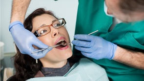 an emergency dentist examining a patient’s mouth