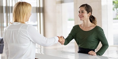 Dental employee shaking hands with a patient.