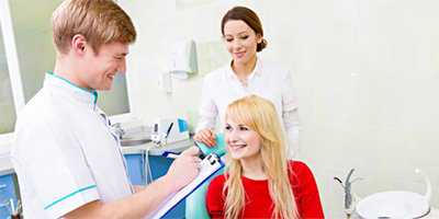 Woman in dental chair smiling at dentist